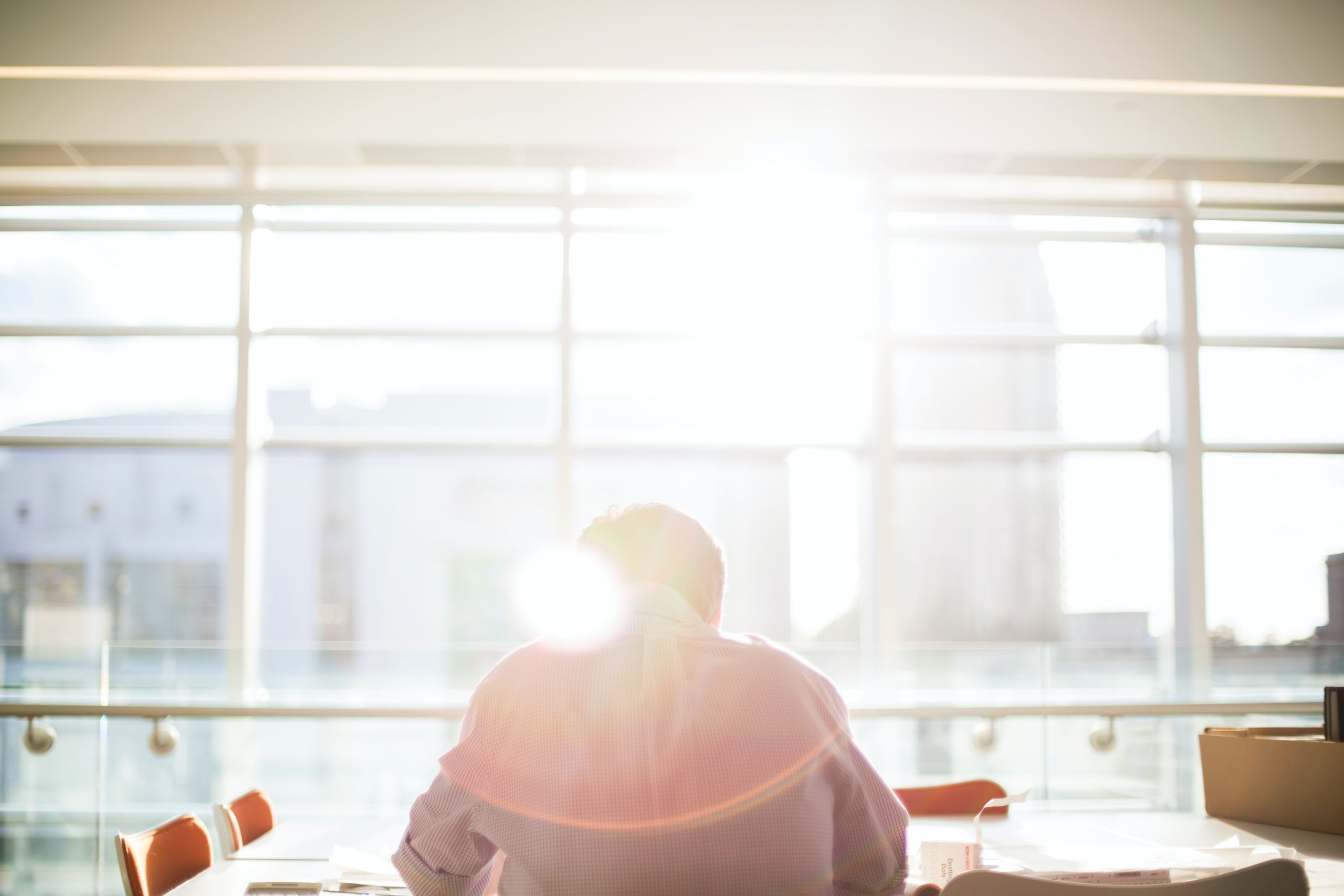 man at desk with red chairs taking core competency assessment