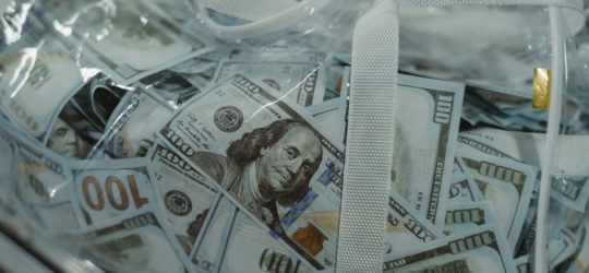 hundred dollar bills in a clear plastic bag