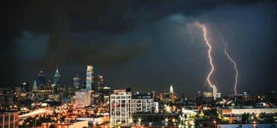 Lightning striking down on a city at night