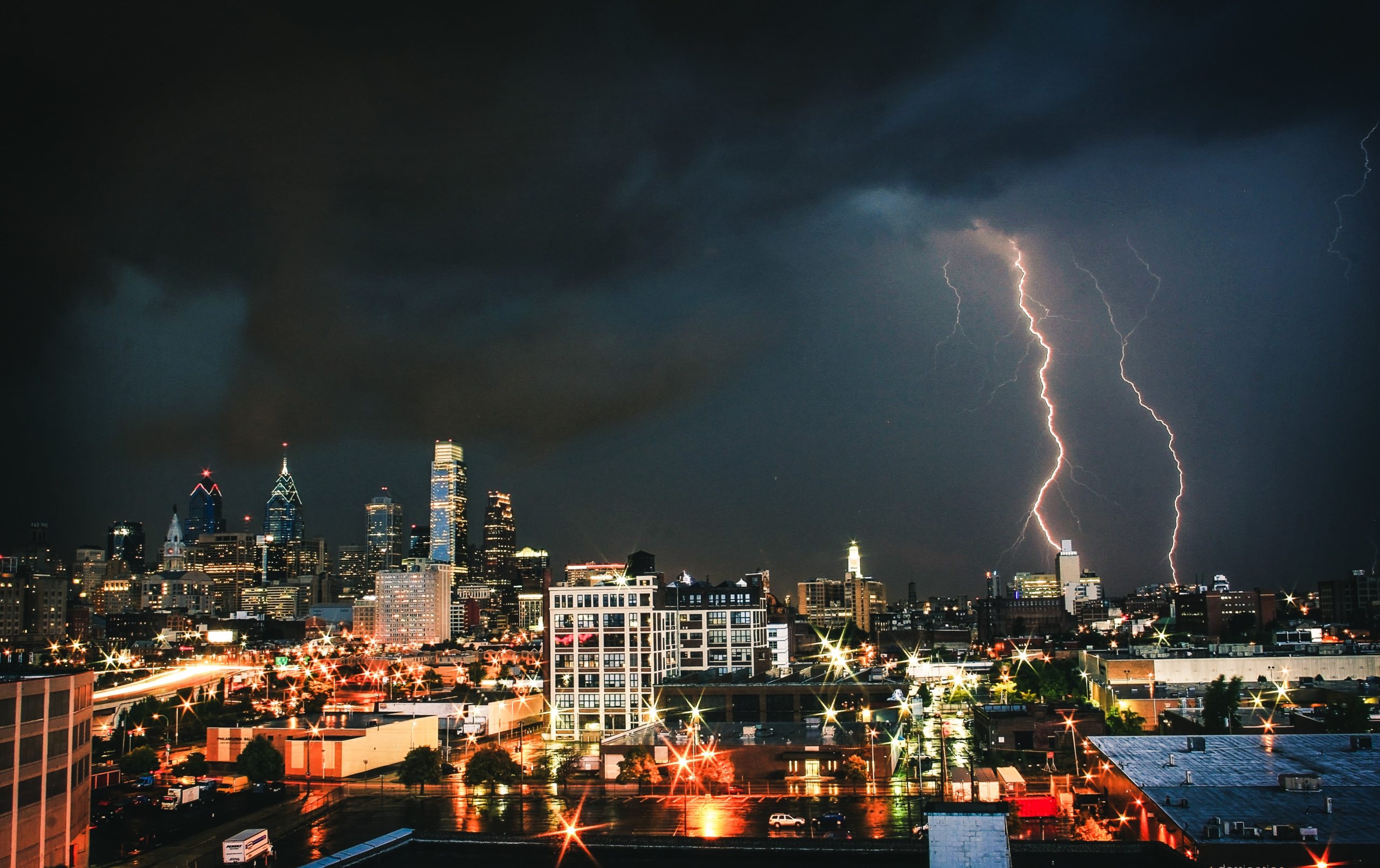 Lightning striking down on a city at night