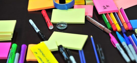 colorful post-its and office supplies scattered on a table