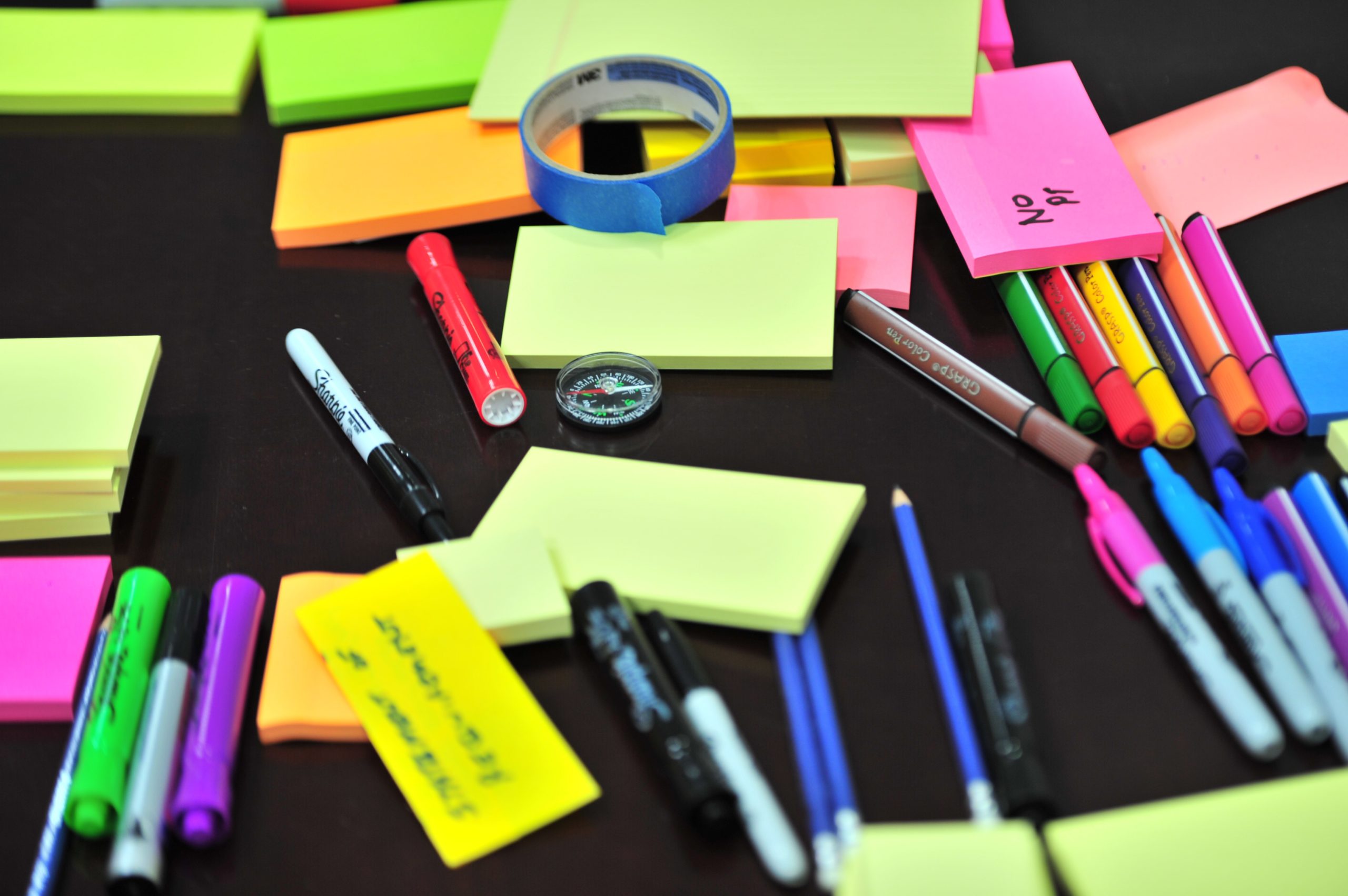 colorful post-its and office supplies scattered on a table