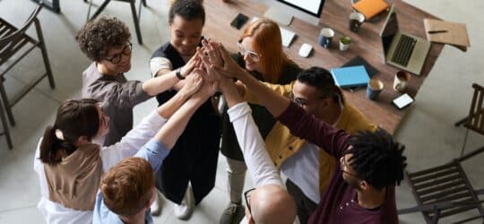 Seven employees high fiving in a circle