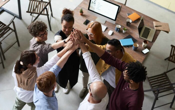 Seven employees high fiving in a circle