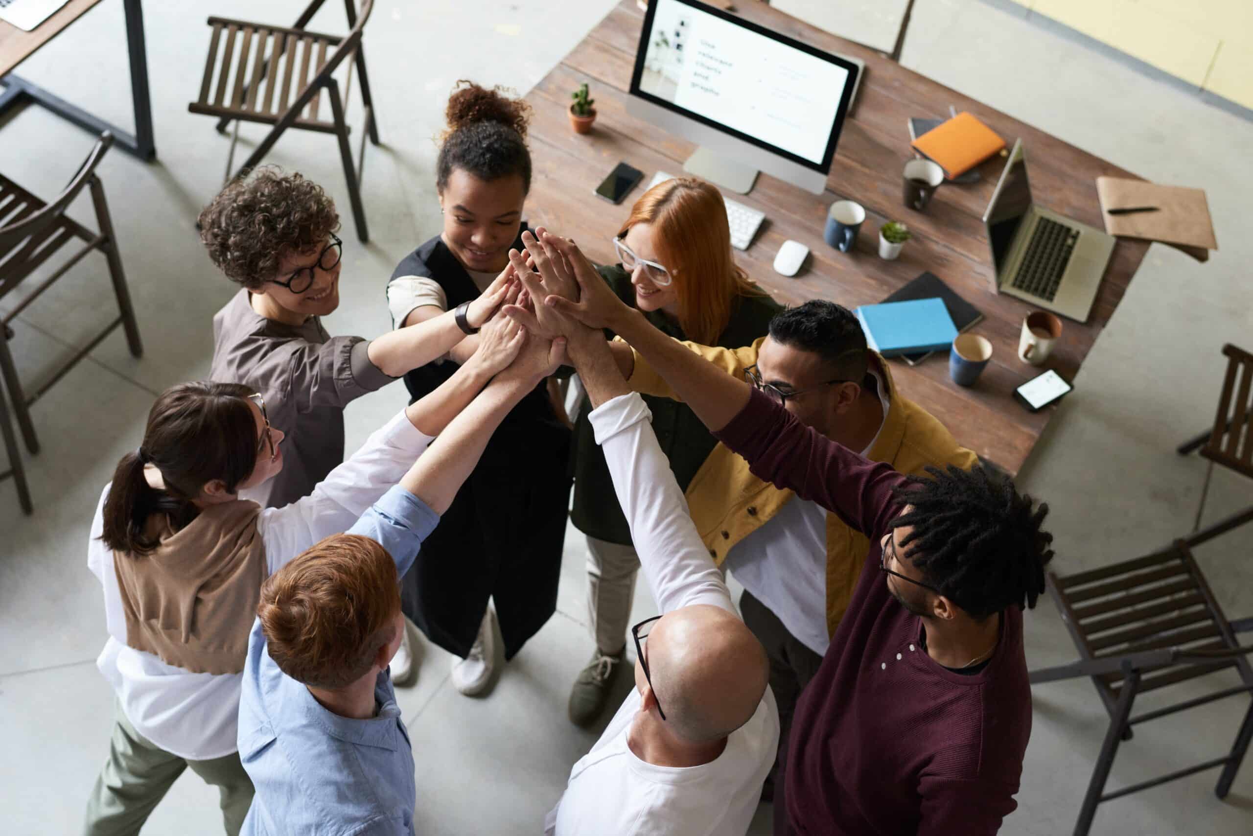 Seven employees high fiving in a circle