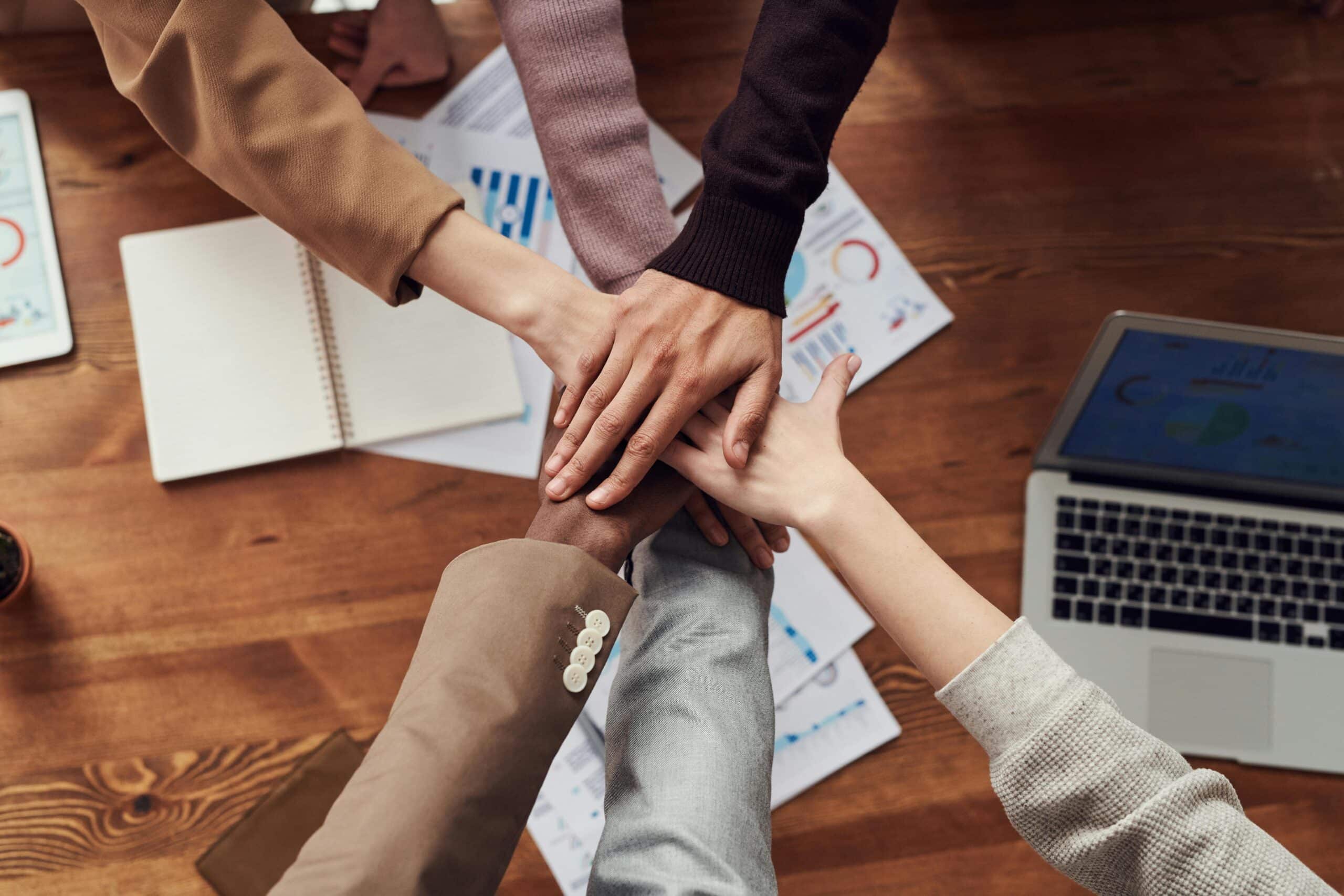 HR team hands in huddle