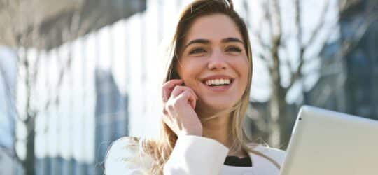 employee on phone with laptop smiling